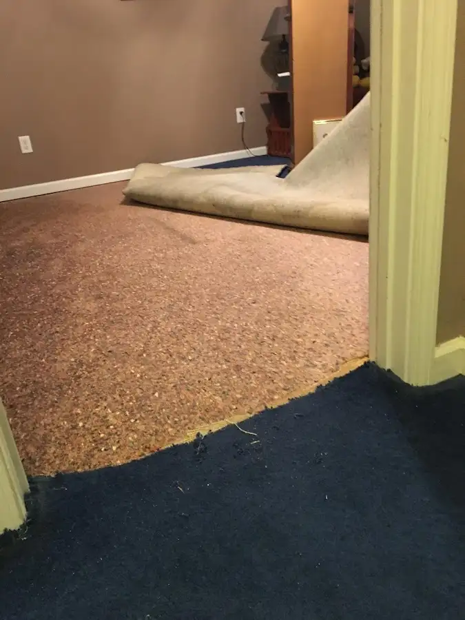 Carpet pad removal revealing water damage during Water Mitigation Services in Altus
