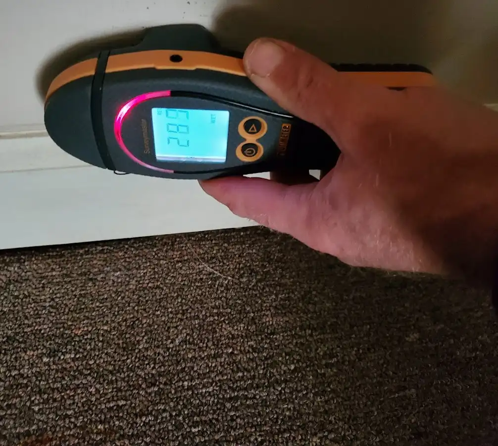 Moisture detection at baseboard during Storm Damage Restoration in Altus